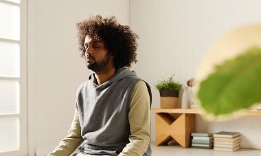 man sitting calmly on floor in home 