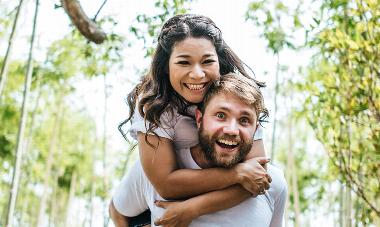 man carrying woman on back smiling